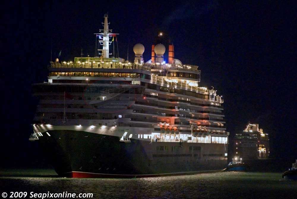QUEEN VICTORIA (2007/90049grt/IMO 9320556) inbound from Rarotonga, seen moments before the first glimpse of dawn, glides toward her berth at Princes Wharf, Auckland, NZ, one of the many ports of call for the Cunard ship during her second Round-the-World cruise. She was followed minutes astern of her by Princess Cruises' TAHITIAN PRINCESS (1999/30277grt/IMO 9187899, ex-R-FOUR. Renamed OCEAN PRINCESS then SIRENA in 2016. She is due to be renamed AMBELLA in 2026) which arrived from Nukualofa. They joined Mitsui's NIPPON MARU in port making it one of the busiest days on record for the Port of Auckland. Between 9-15 February 2009, twelve cruiseships will have visited Auckland shattering the previous record of nine vessel visits within a seven day period set in February 2007. 12 February 2009. Photo by Â© 2009 SeapixOnline.com/Trevor Coppock
