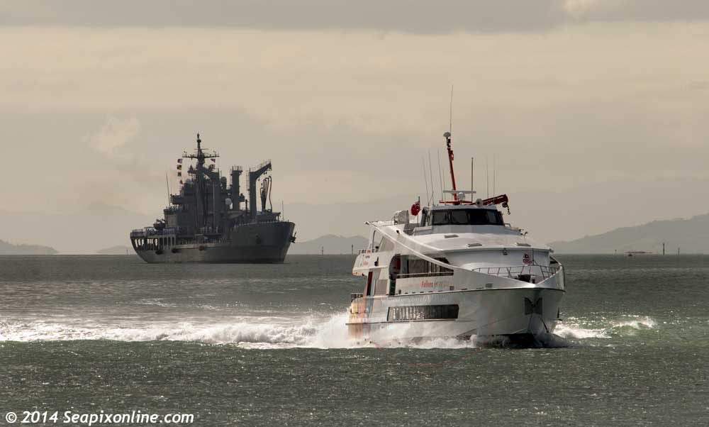 JET RAIDER- built 1990 and operated by the Fullers group of Auckland. Seen here inbound from Waiheke Island to the Auckland downtown ferry basin. In the distance is the inbound visiting South Korean fast combat supply ship ROKS Cheonji. 13 October 2014. Photo by Â© 2014 SeapixOnline.com