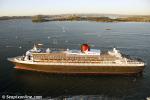 ID 8963 QUEEN MARY 2 (2003/148528grt/IMO 9241061) - accompanied by a welcoming flotilla, approaches North Head (left distance) to enter Aucklands' Waitemata Harbour and begin her maiden call at the City of...