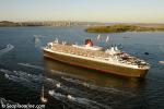 ID 8964 QUEEN MARY 2 (2003/148528grt/IMO 9241061) - accompanied by a welcoming flotilla, rounds North Head (centre distance) to enter Aucklands' Waitemata Harbour and begin her maiden call at the City of...