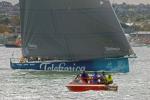 ID 7809 TEAM TELEFONICA - the Spanish entrant in the 2011/12 Volvo Ocean Race, heads down harbour as the fleet compete in the in-port practice racing. Local fishermen look completely unimpressed and...